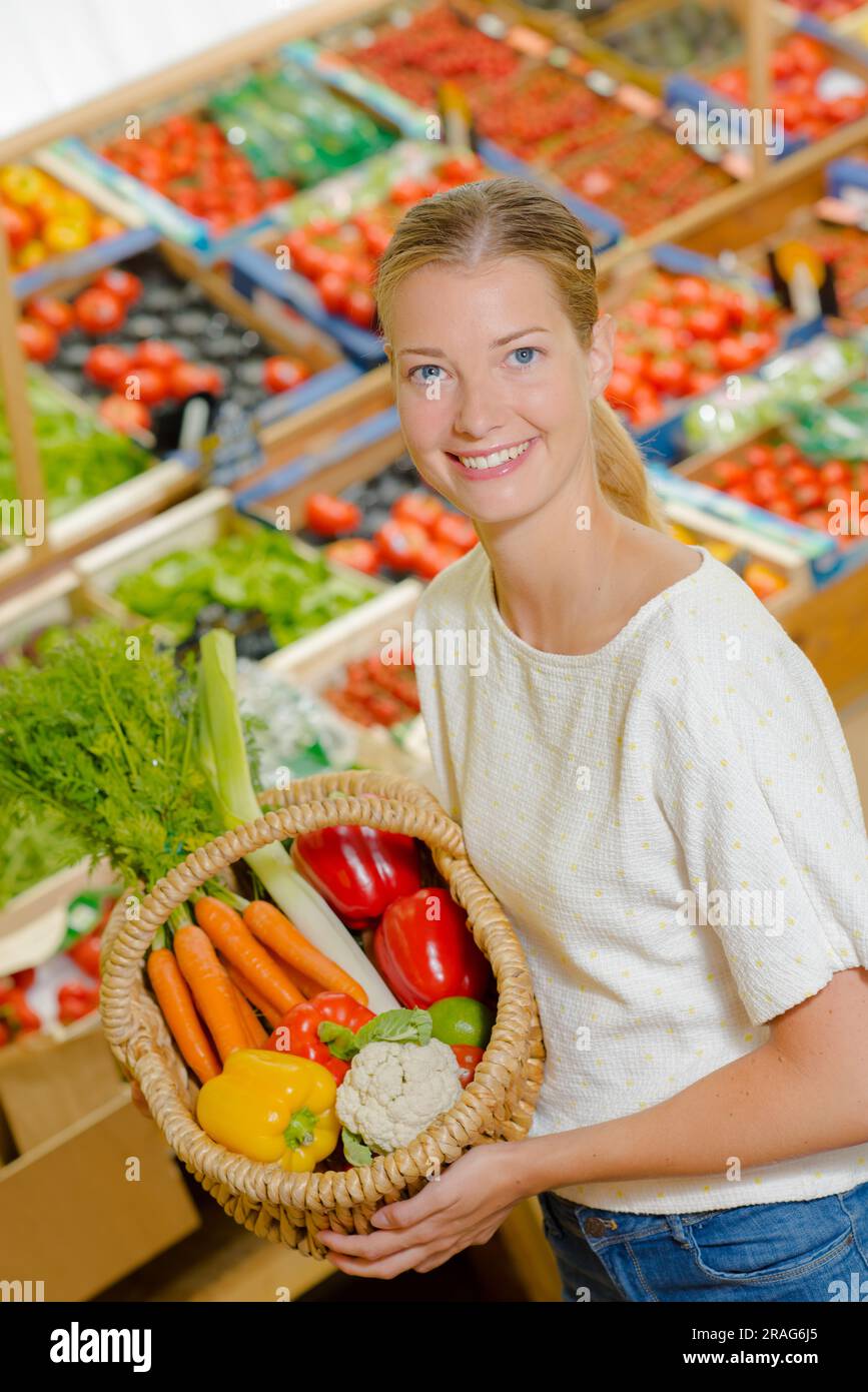 Woman holding up her shopping basket Stock Photo - Alamy