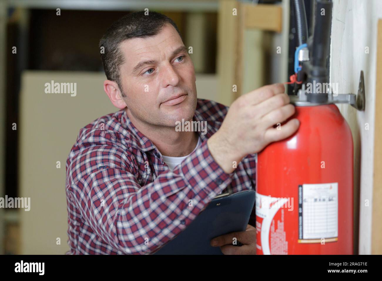 man using fire extinguisher against grey background Stock Photo