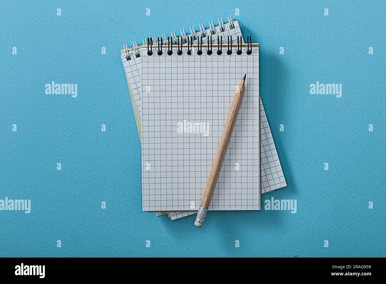 Opened Notepads With Pencil On Blue Background Stock Photo
