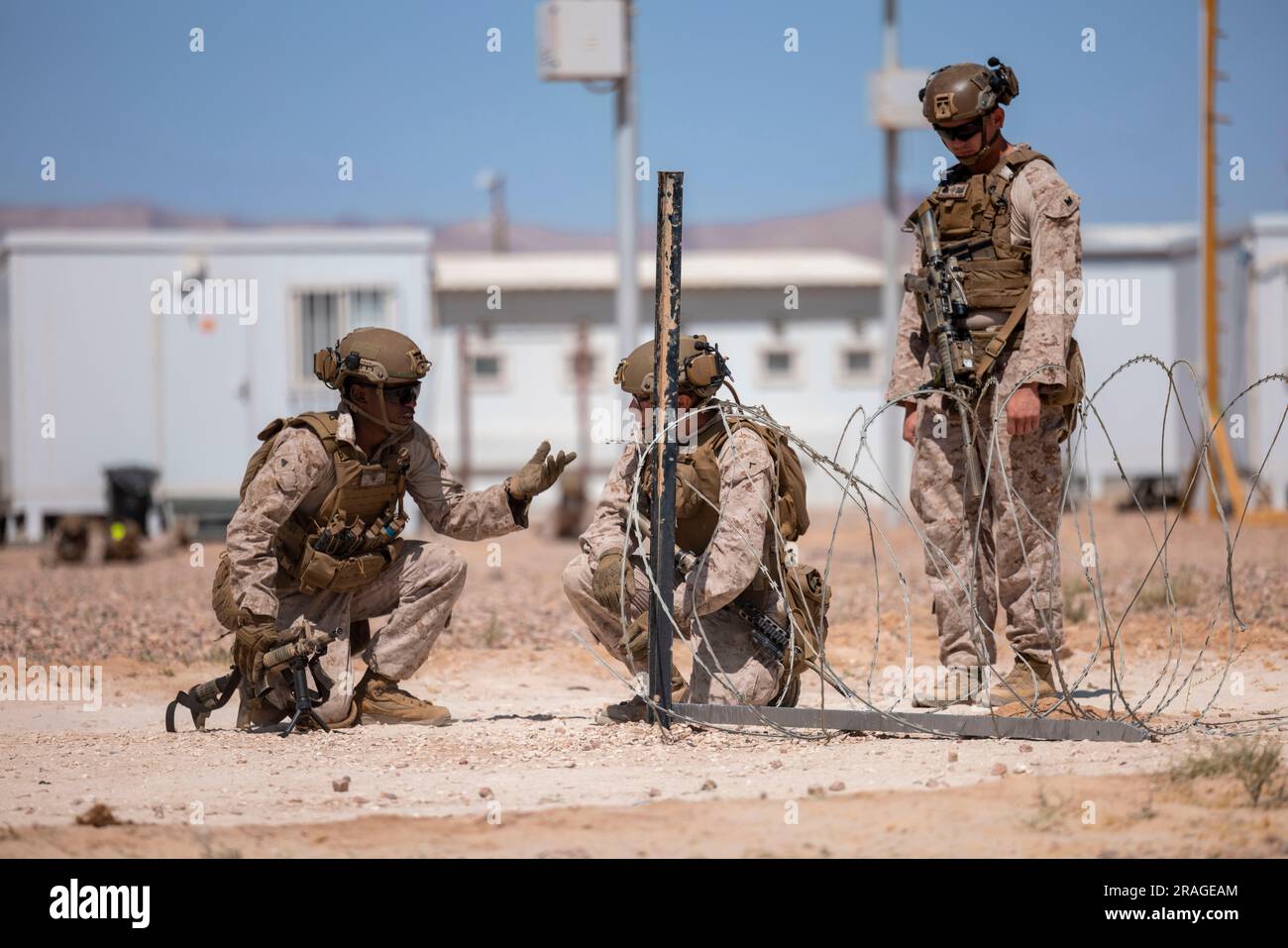 U.S. Marine Corps Corporal Adonis Watts and Pfc. Jaden Novelo with 1st Combat Engineer Battalion, 1st Marine Division, coordinate with each other while conducting a concertina wire breaching scenario with a notional bangalore torpedo as Sgt. Marcus Sanchezclifton evaluates the two during Intrepid Maven 23.4, July 2, 2023. Intrepid Maven is a bilateral exercise between U.S. Marine Corps Forces, Central Command and Jordanian Armed Forces designed to improve interoperability, strengthen partner-nation relationships in the U.S. Central Command area of responsibility, and improve both individual an Stock Photo