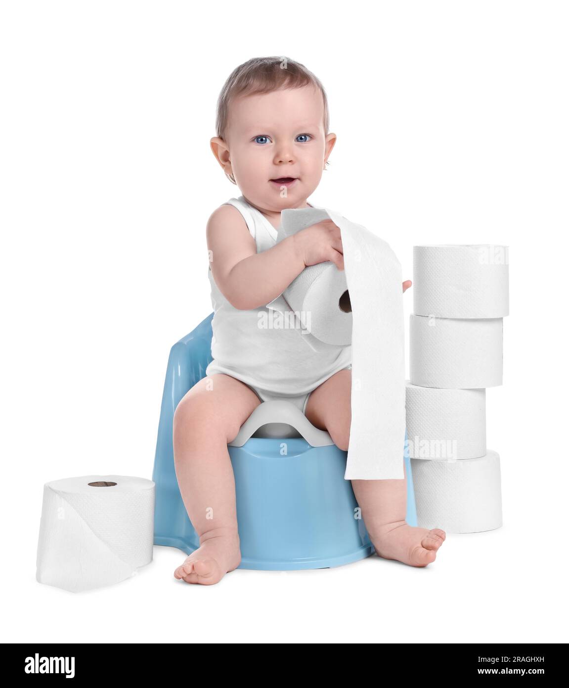 Little child sitting on baby potty and stack of toilet paper rolls ...