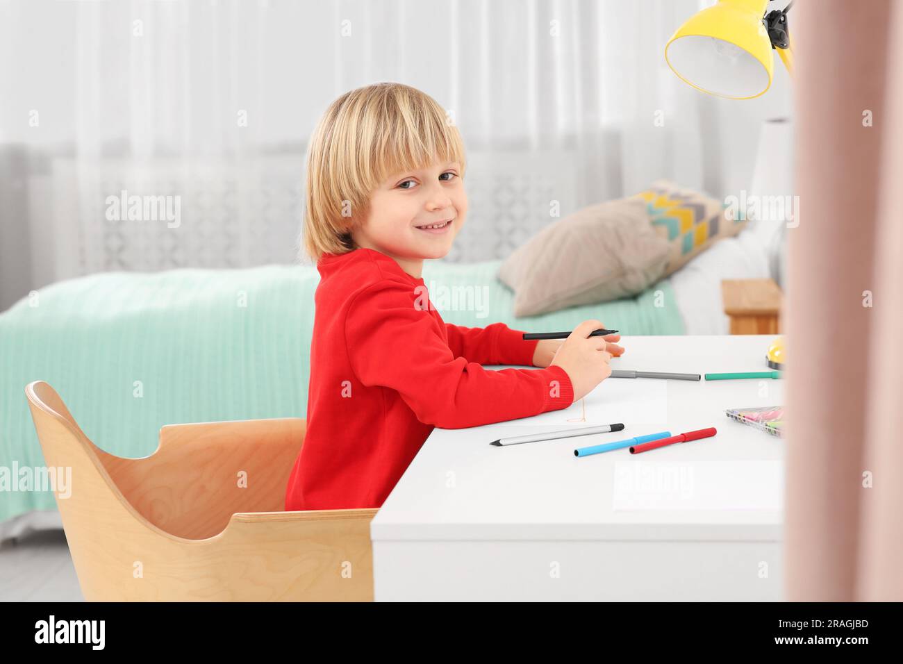 Little boy drawing at desk in room. Home workplace Stock Photo - Alamy
