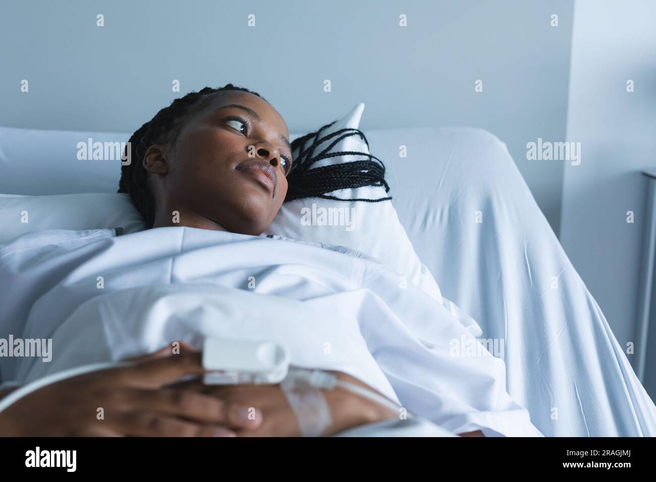 African american female patient with pulse oximeter on hand, lying on