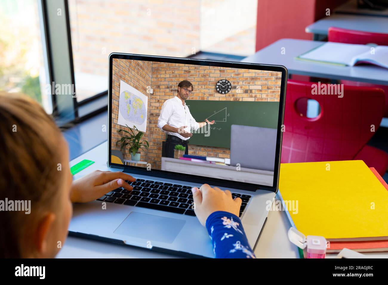 Diverse schoolgirl with male teacher having class during laptop video ...