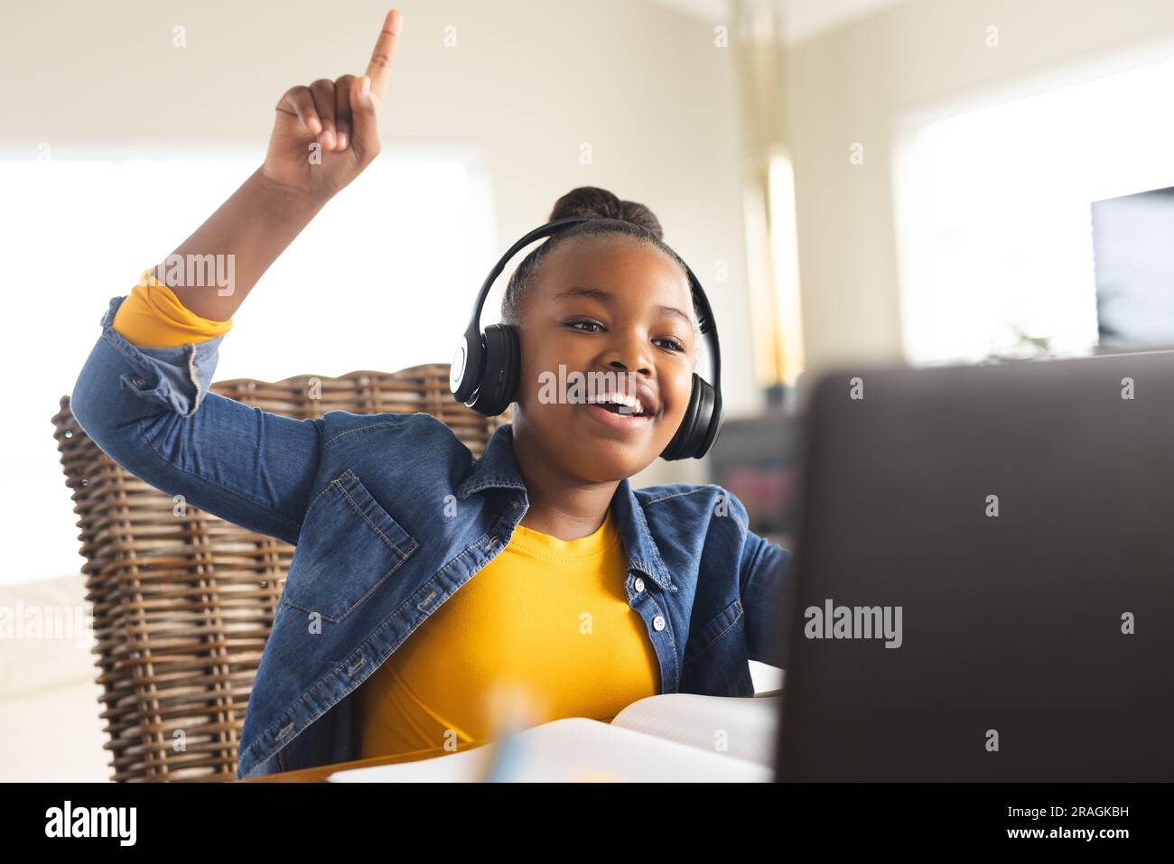 Happy african american girl sitting at table using laptop for online ...