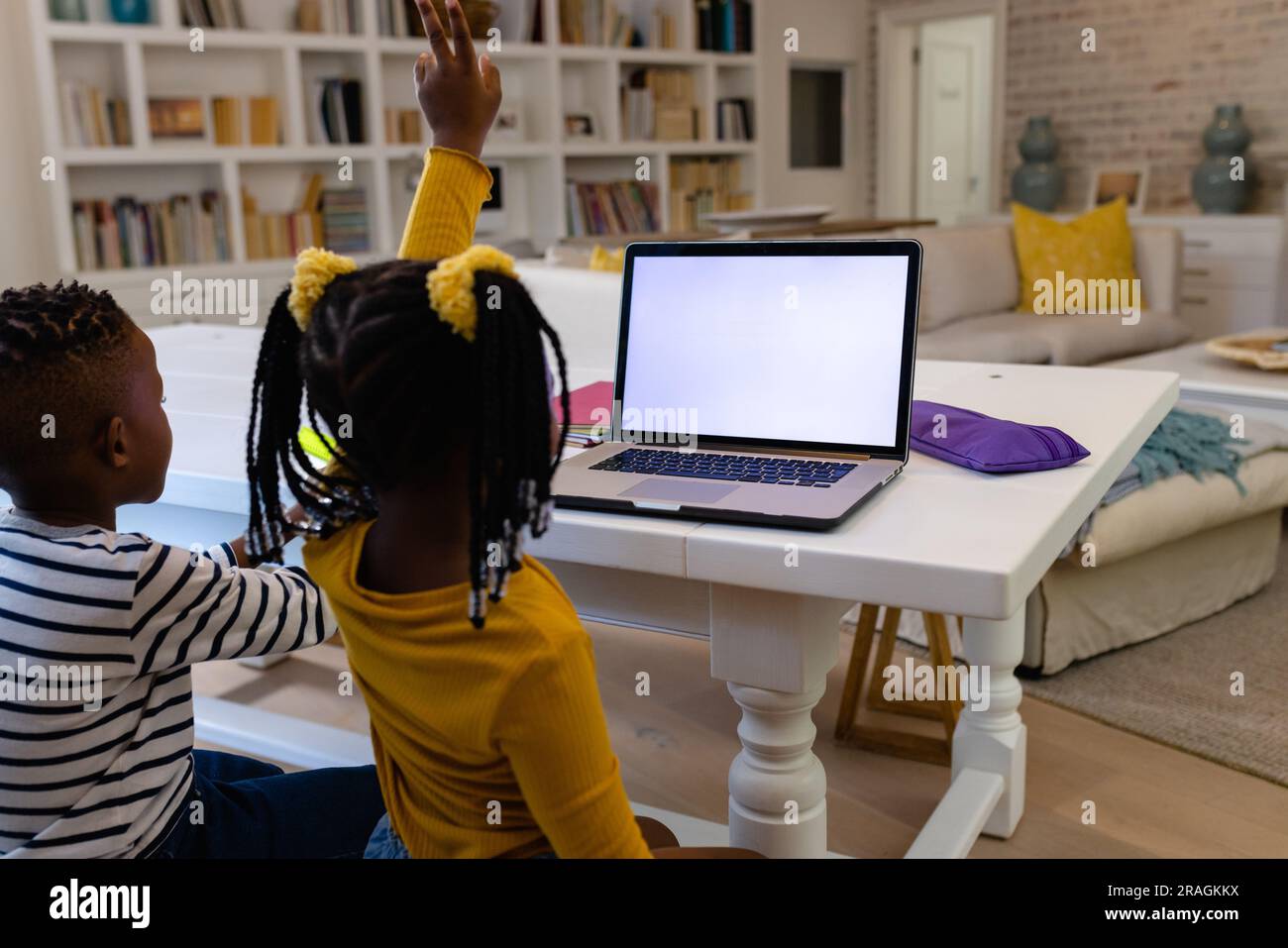 African american girl raising hand while attending online class with ...