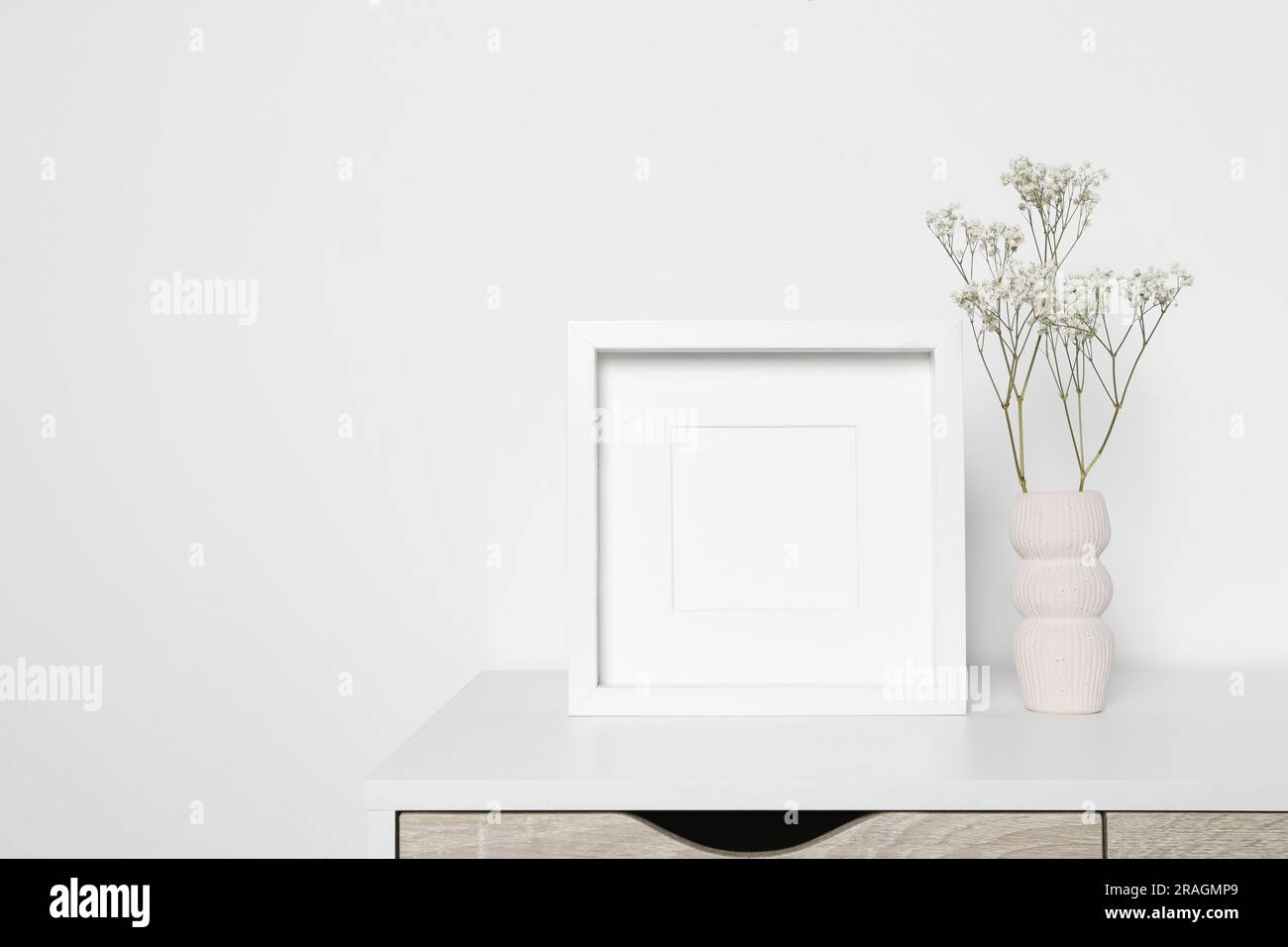 Empty photo frame and vase with dry decorative gypsophila flowers on ...