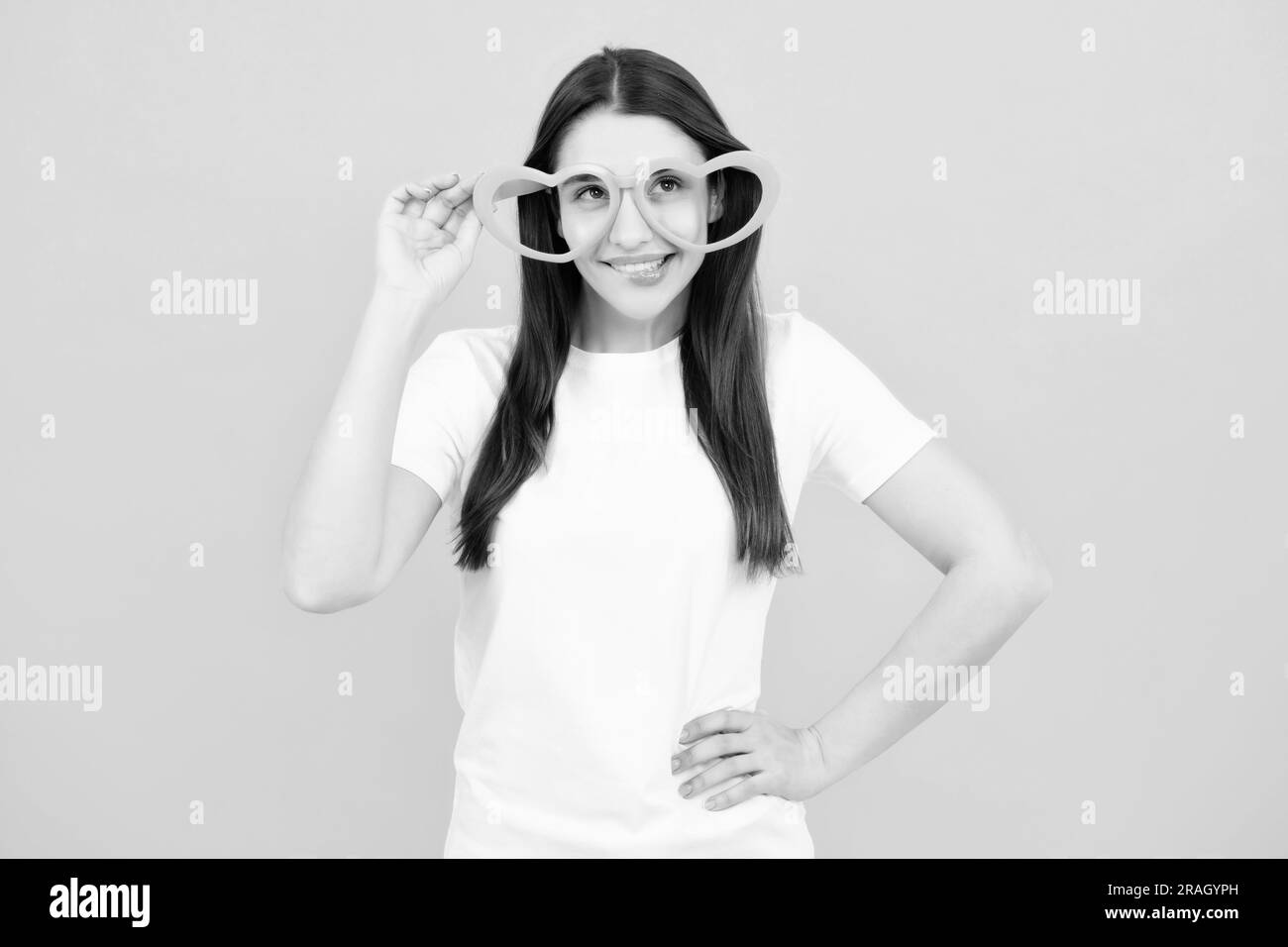 Girl with heart shaped glasses funny and smiling on yellow studio background Stock Photo Alamy