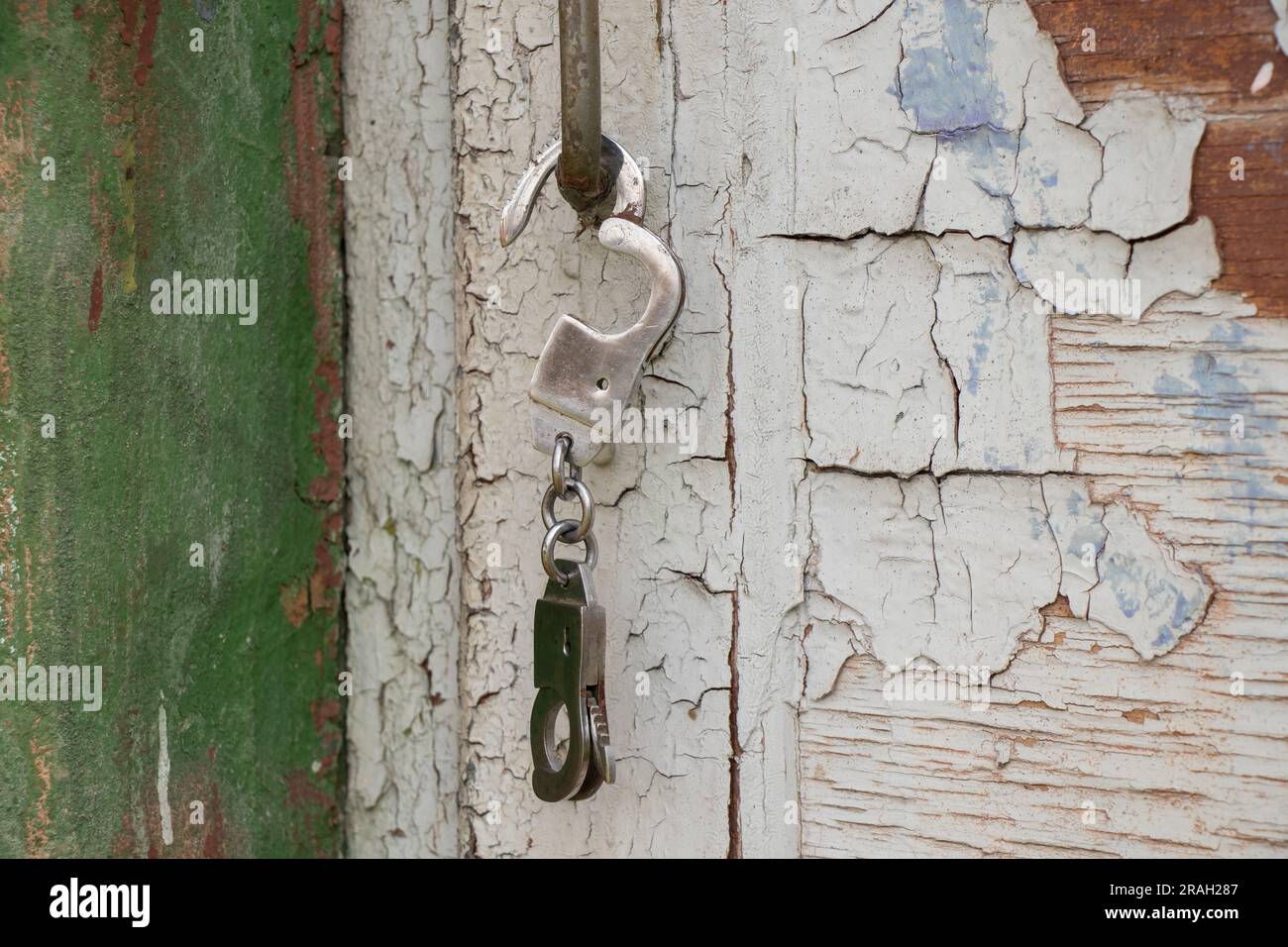 iron handcuffs hanging on the doorknob in the street Stock Photo