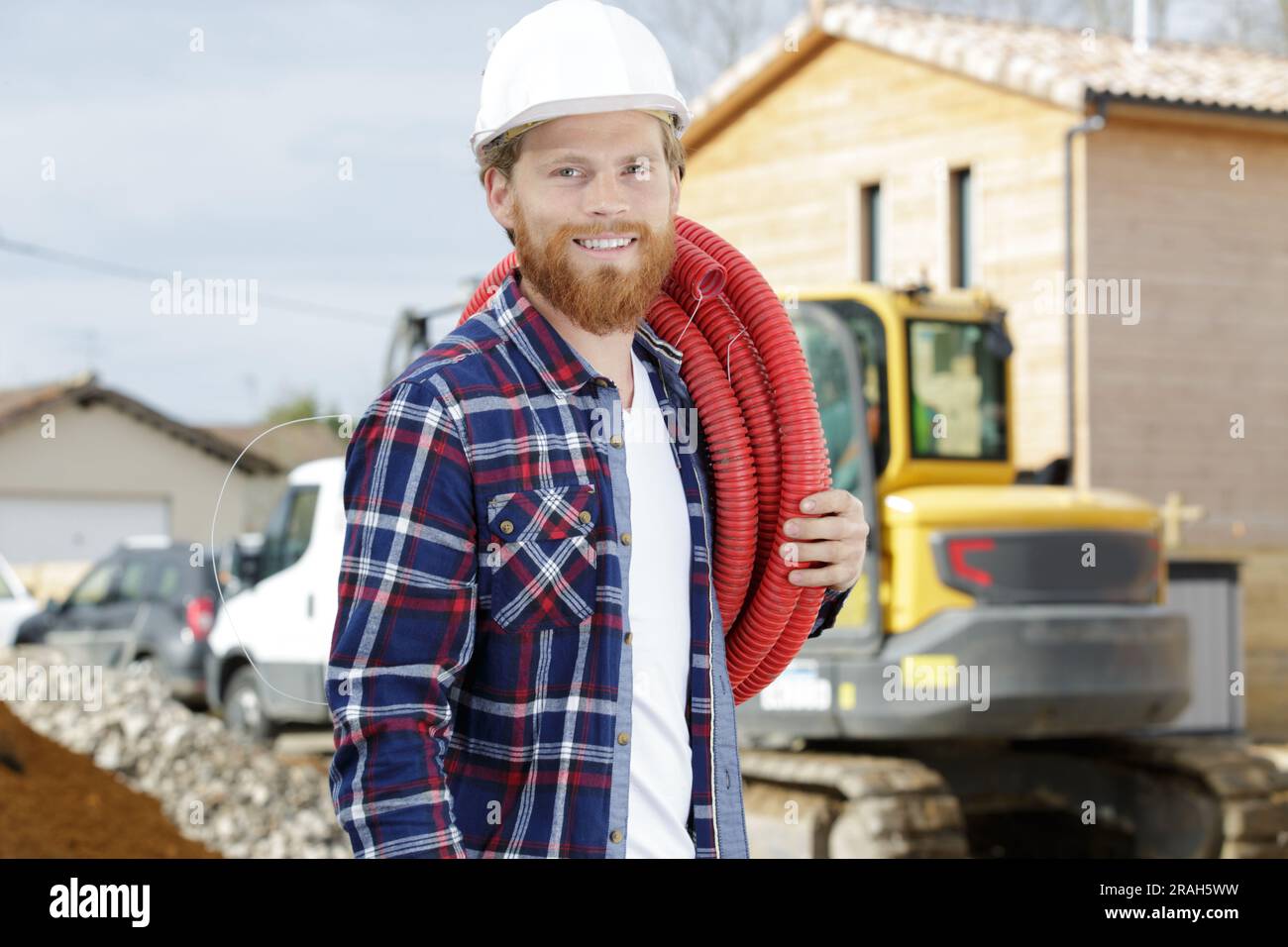 happy worker moving pipes outdoors Stock Photo