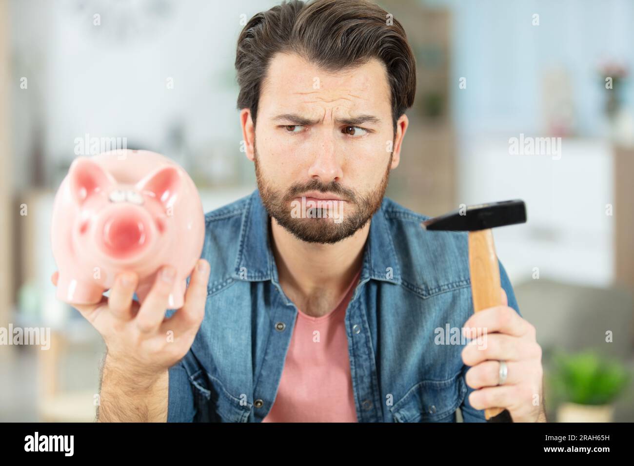 man about to break a piggybank Stock Photo - Alamy