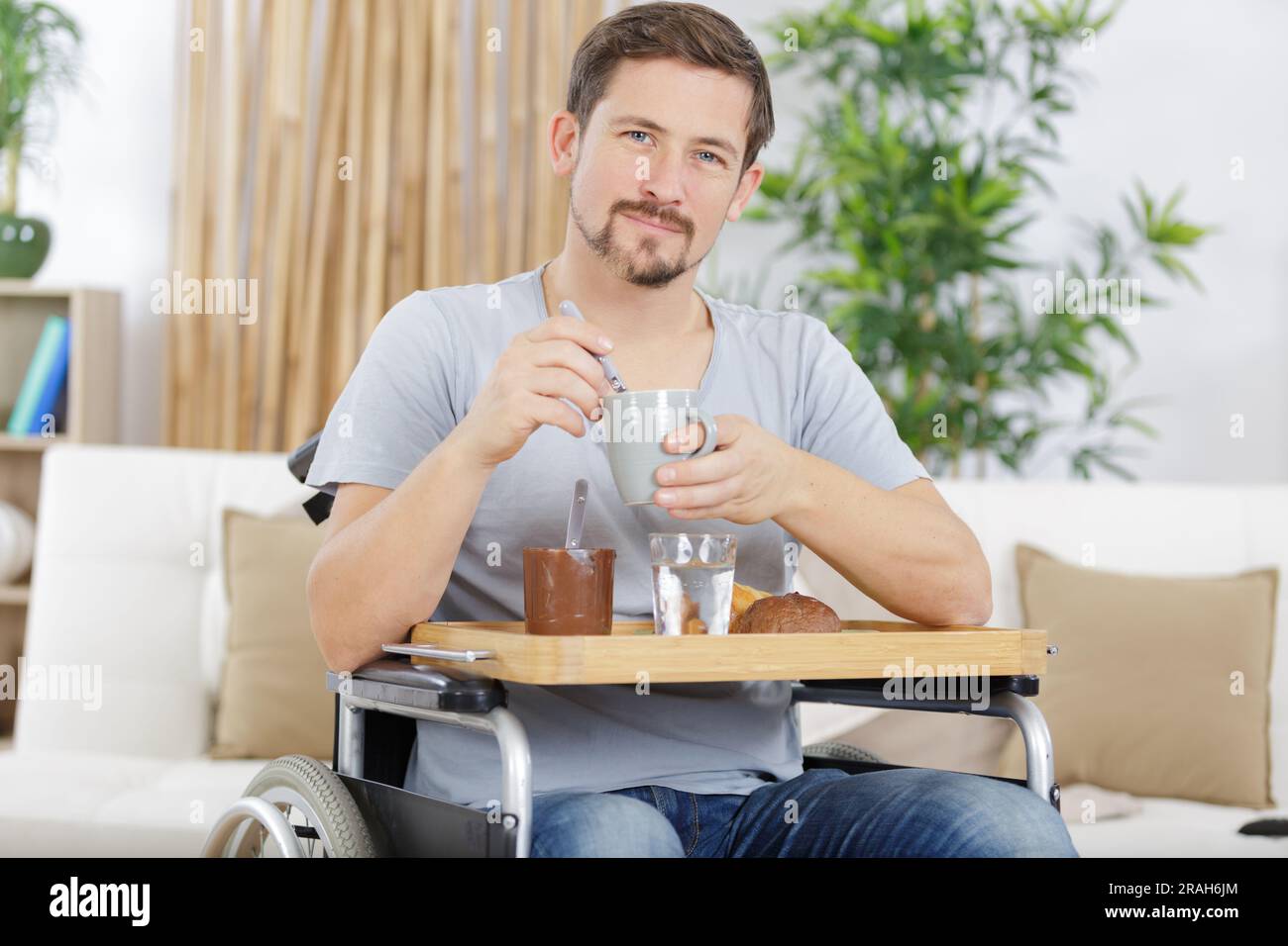handsome man in wheelchair having breakfast Stock Photo