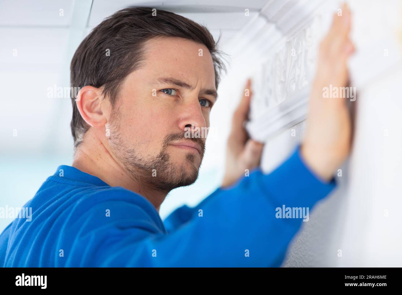 worker installing window curtain rod on the wall Stock Photo