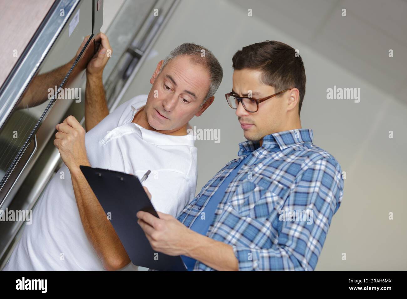 two technician fixing an oven Stock Photo Alamy