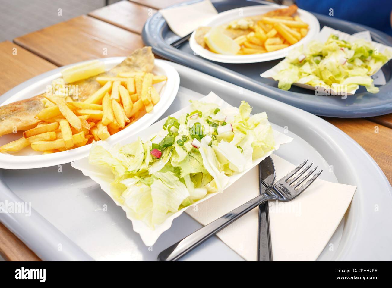 Fish and chips on a plate. Fried fish with butter on it and french fries on plastic plate in restaurant Stock Photo