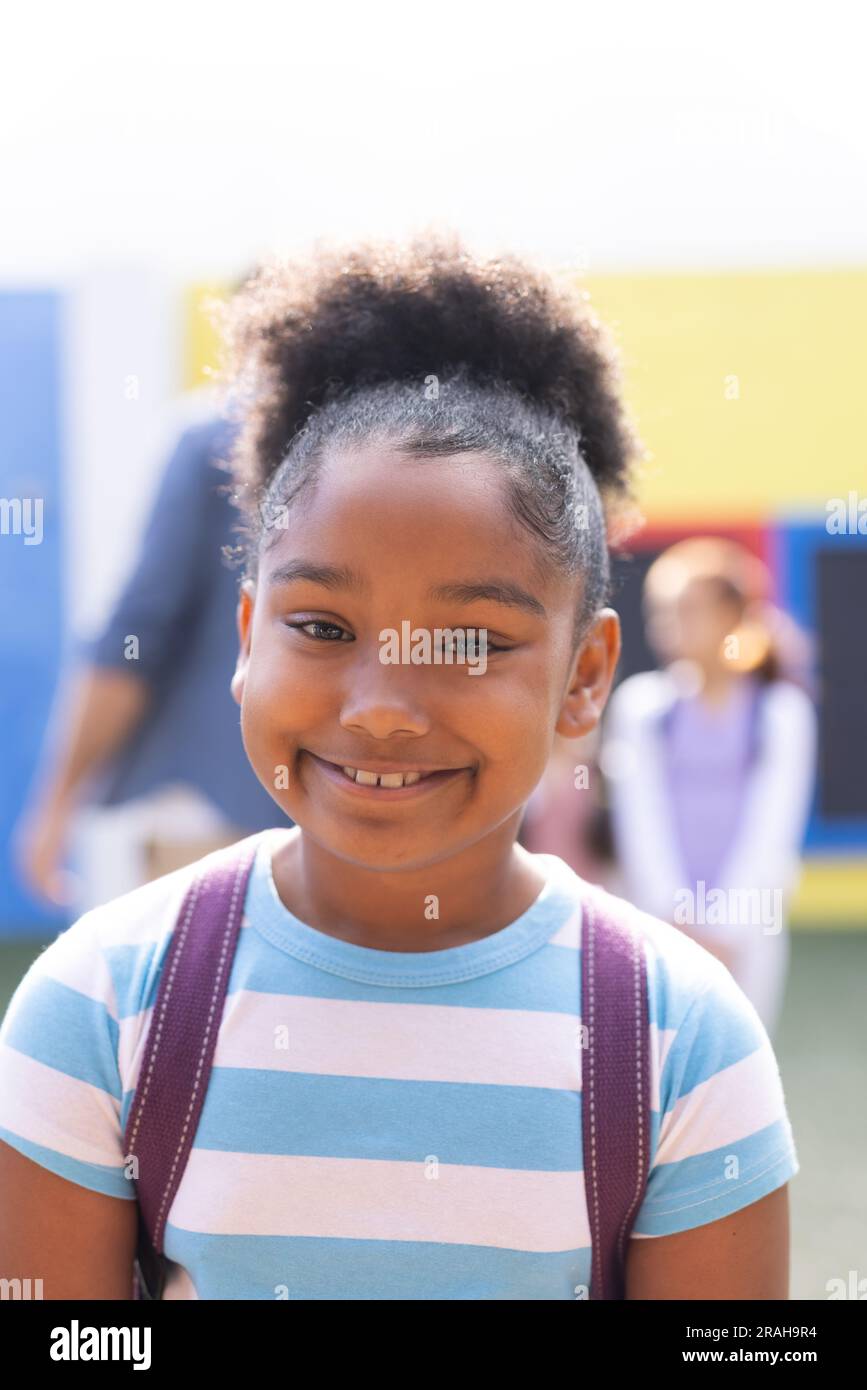 Vertical portrait of smiling african american elementary schoolgirl in ...