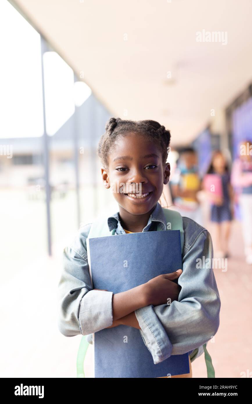 Vertical portrait of smiling african american girl in elementary school ...