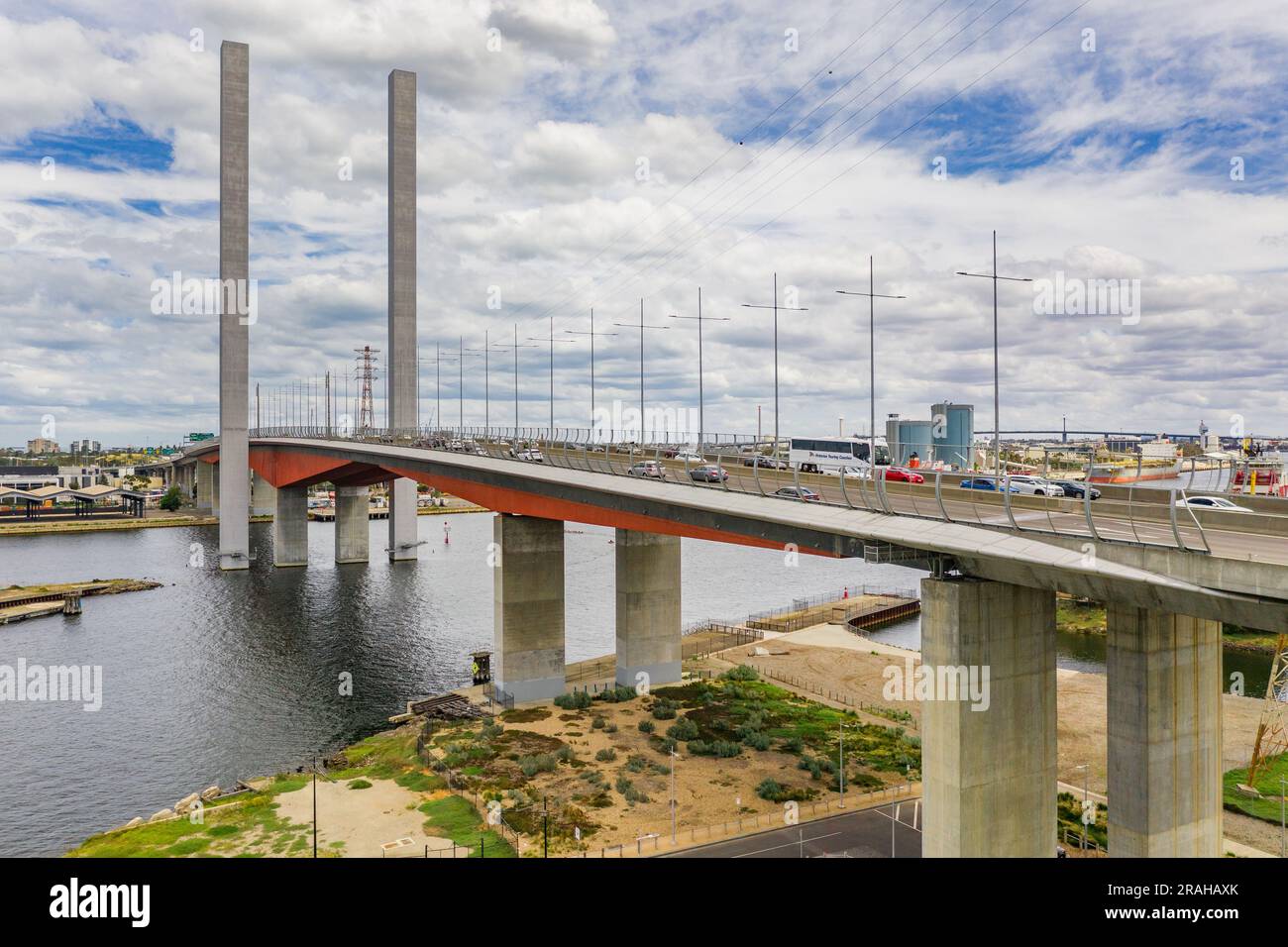 Aerial view of long bridge with twin towers spanning a wide river at