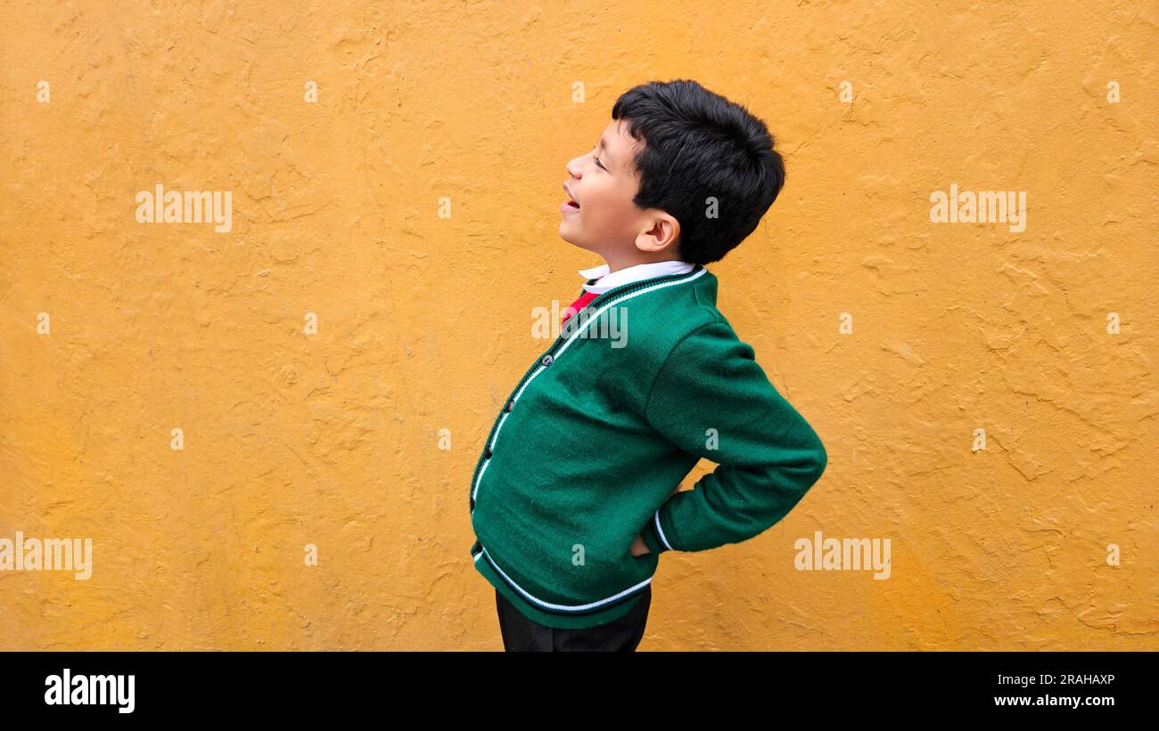 9yearold darkskinned Latino boy in school uniform suffers from back and neck pain from