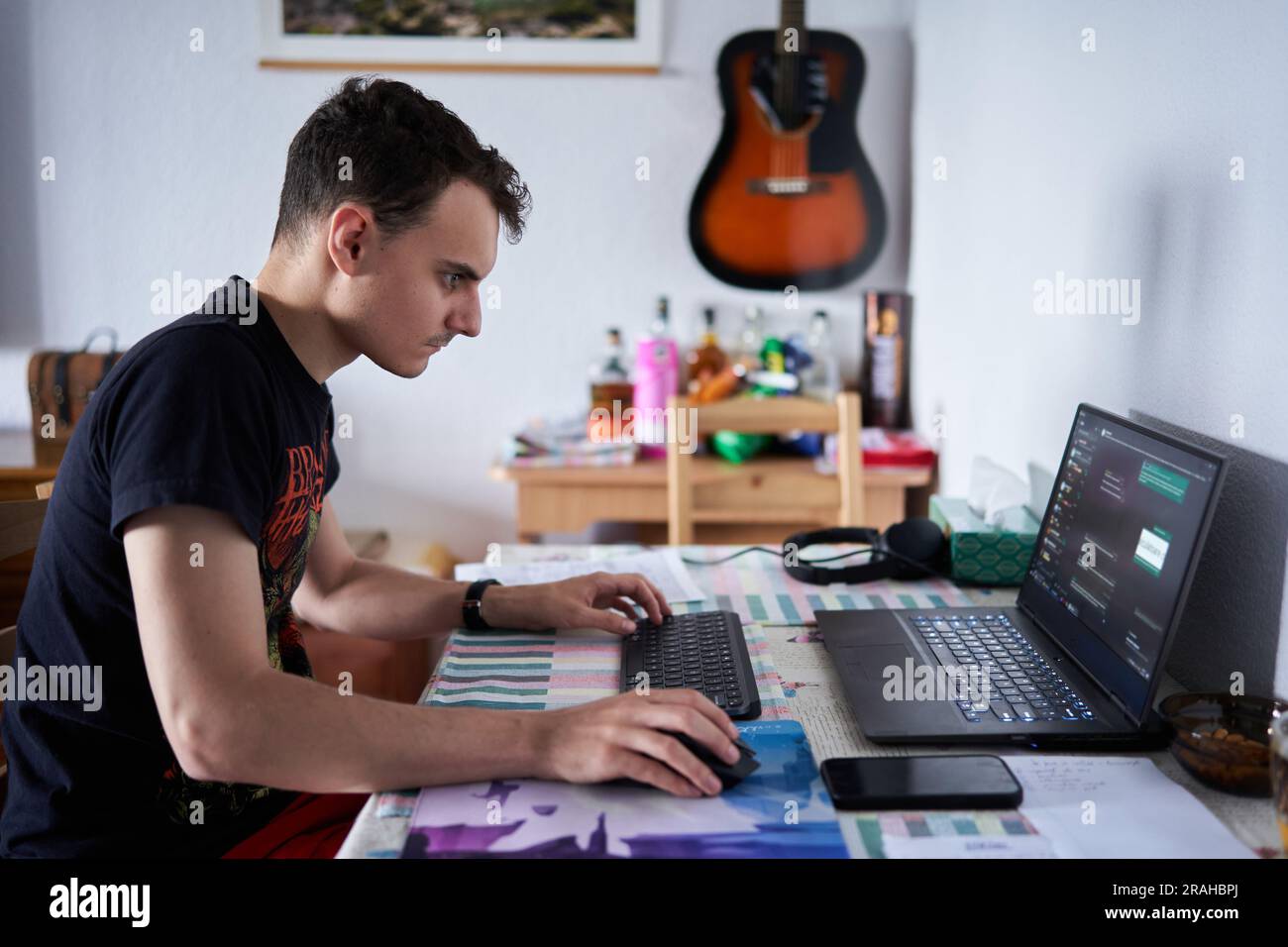 Young man software developer working from home on his laptop Stock Photo