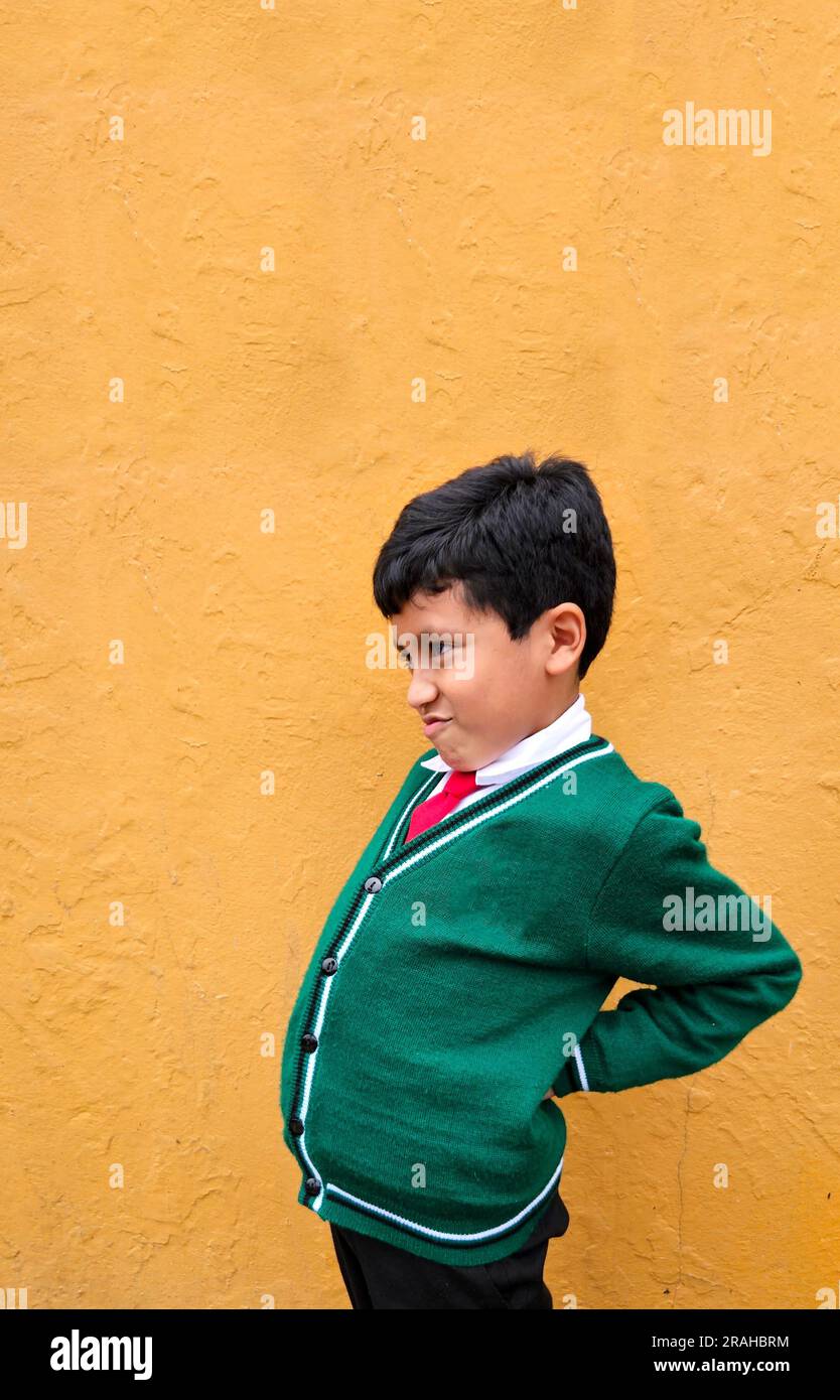9yearold darkskinned Latino boy in school uniform suffers from back