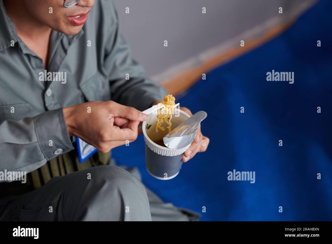 Worker eating instant noodles for lunch at construction site Stock