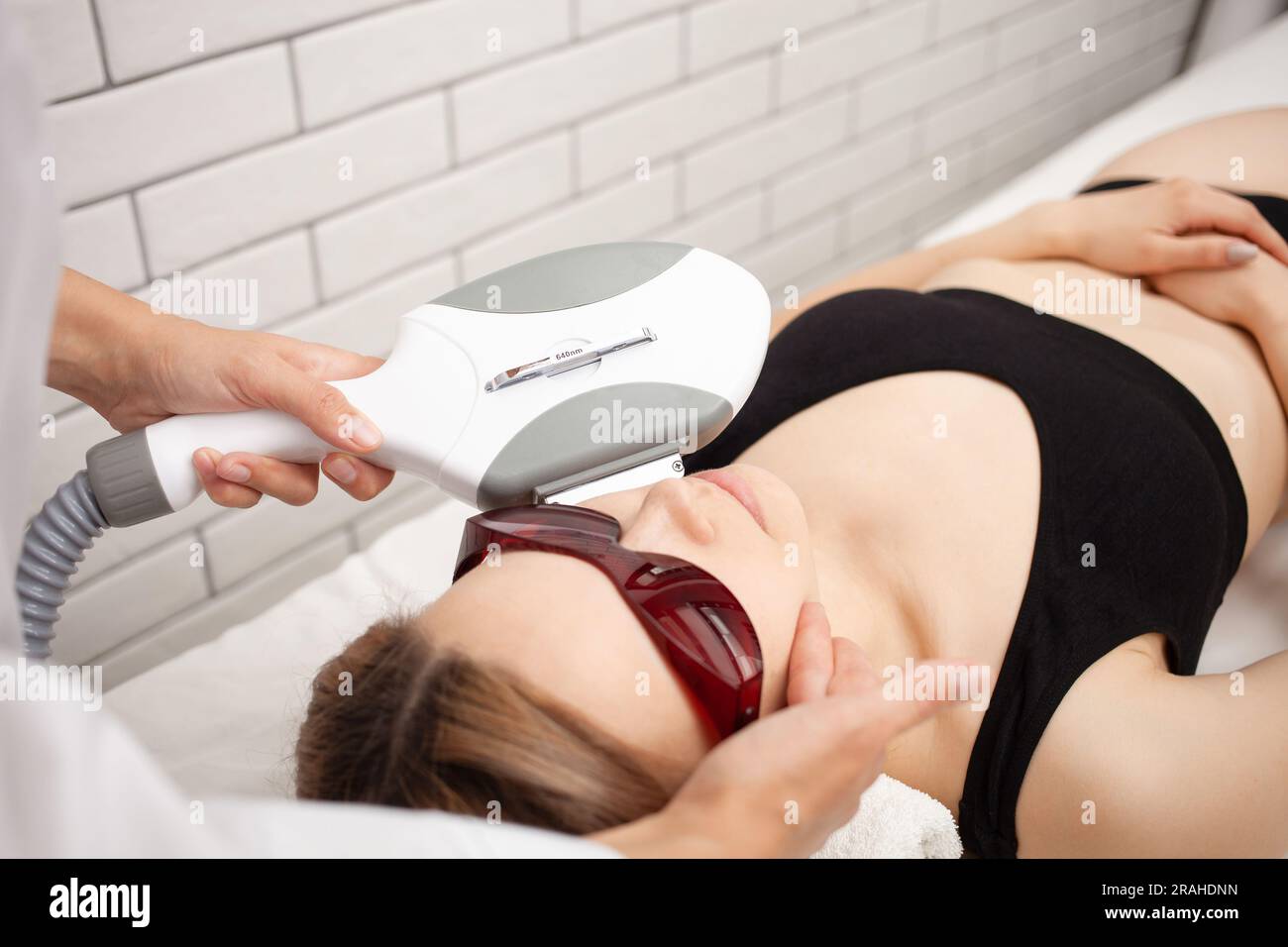cosmetologist woman performs procedure of photoepilation skin