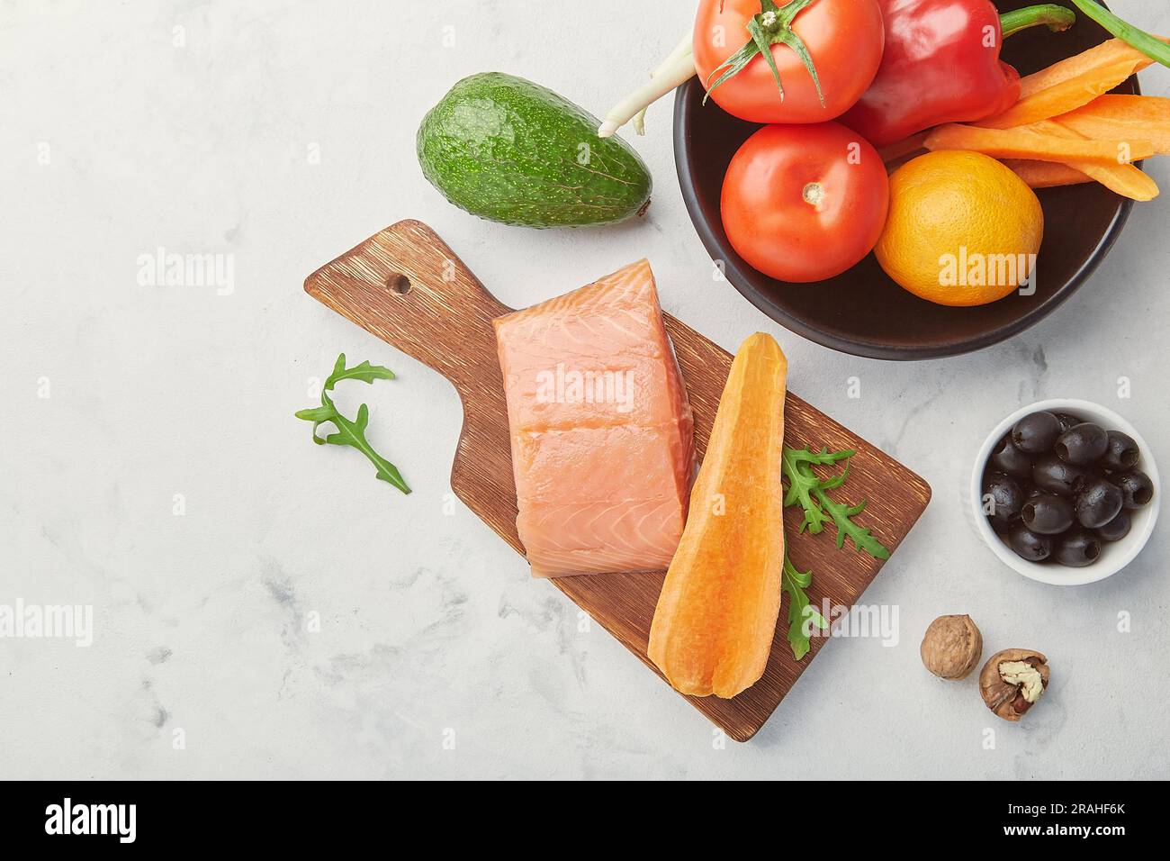 Keto, Low carb, FODMAP diet food with vegetables and fruits, smoked salmon, greens, nuts, olives