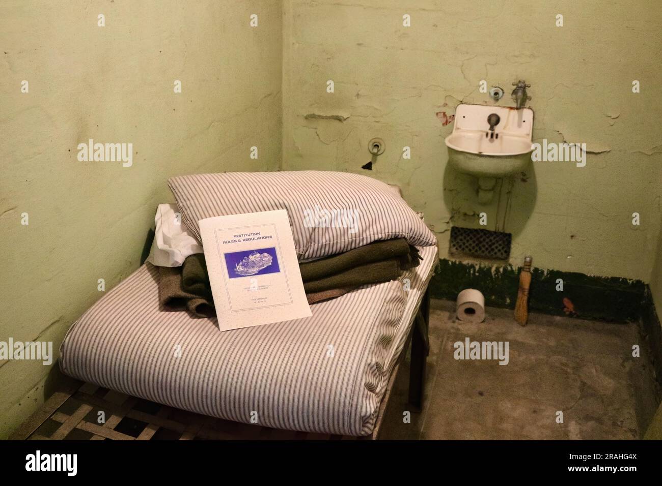 Institution Rules and Regulations document on a mattress inside a prison cell Alcatraz Federal Penitentiary San Francisco California USA Stock Photo