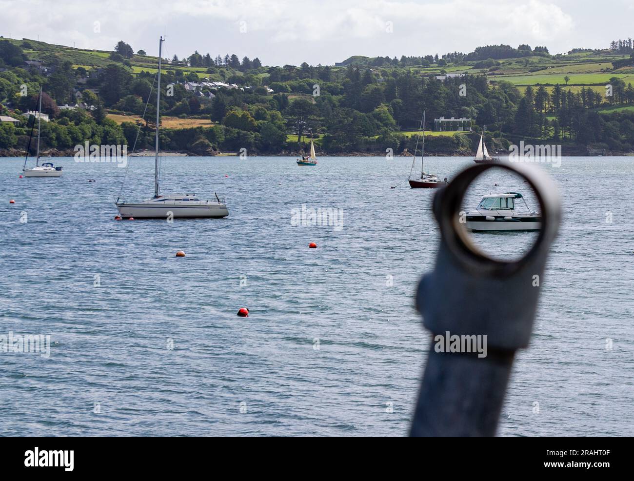 Boats in Harbour or Harbor with boat seen through hole in Guard Rail Stock Photo