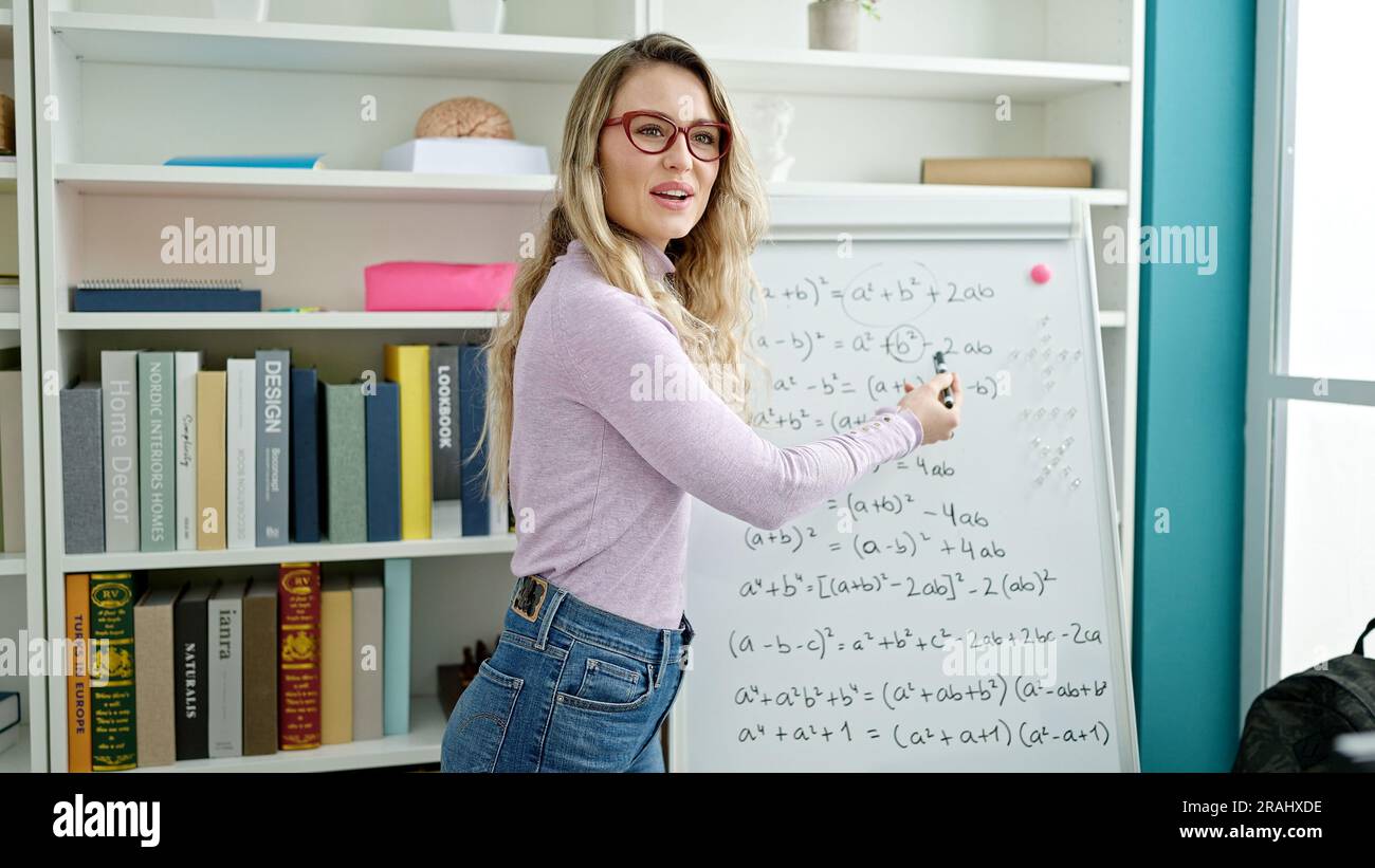 Young blonde woman teacher teaching maths lesson at classroom Stock Photo