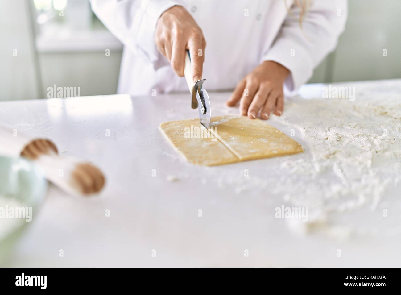 How To Achieve Uniform Texture In Fresh Pasta Dough Reference: Young Woman Wearing Cook Uniform Cutting Pasta Dough At Kitchen