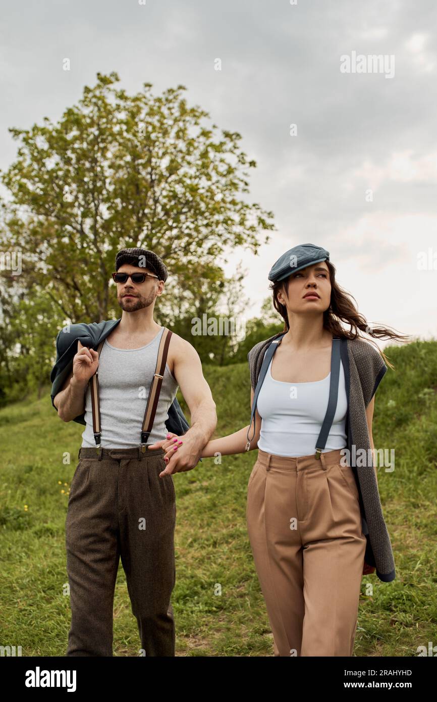 Stylish romantic couple in newsboy caps, suspenders and vintage outfits ...