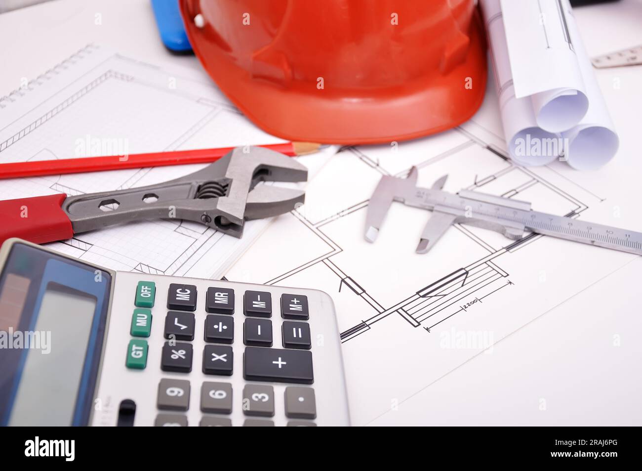 Calculator, helmet and drafting tools on architectural table Stock Photo