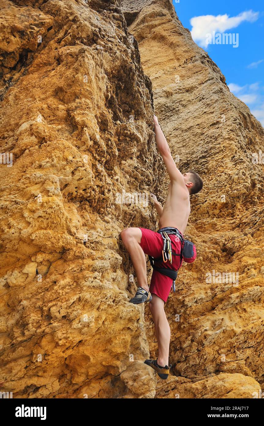 Young man climbing crag hi-res stock photography and images - Alamy