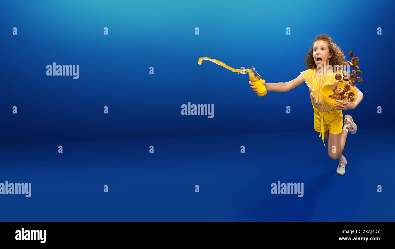 Creative image with teen girl in yellow clothes running and spilling orange juice, throwing
