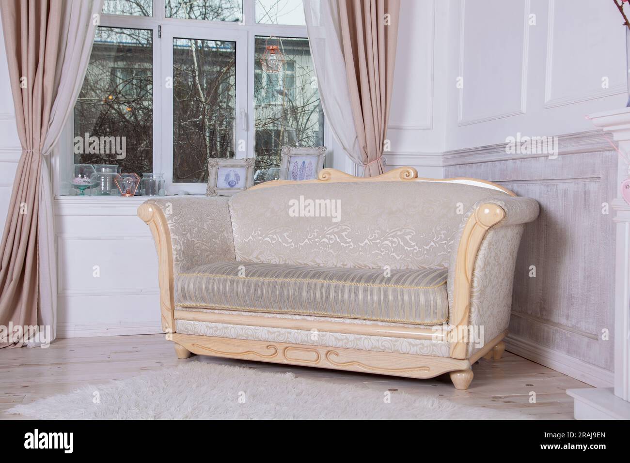 An old sofa with wooden planks by the window. Empire style furniture