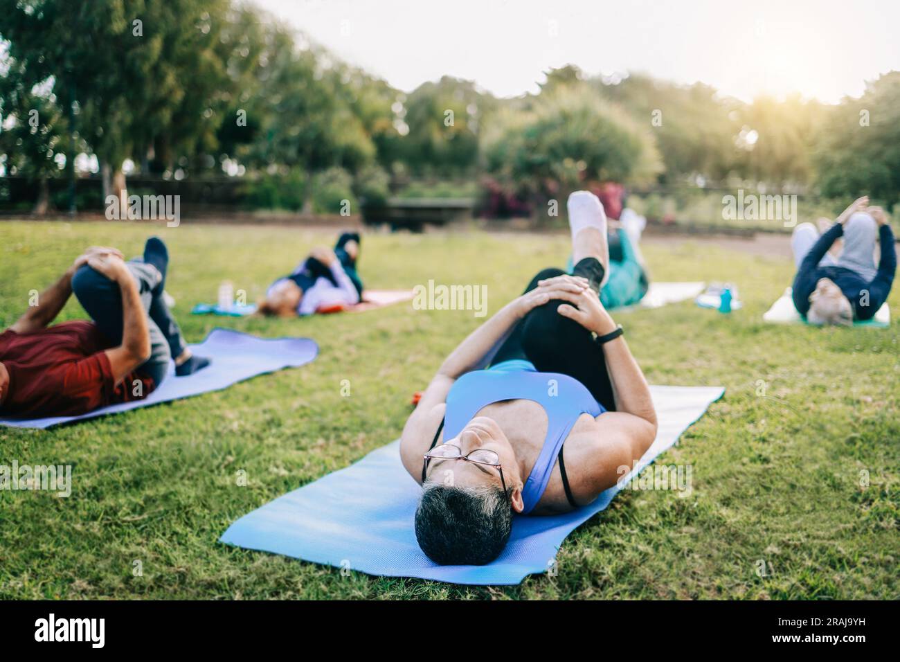 Senior sport people exercising during yoga workout class outdoor at park city - Fitness joyful Elderly lifestyle Stock Photo