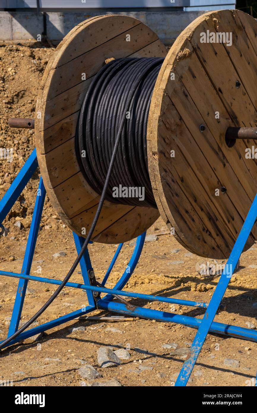 Wooden Coils Of Electric Cable Outdoor. High and low voltage cables. coils industrial wires. Roll of outdoor fiber optic signal shielded cables. Coils Stock Photo