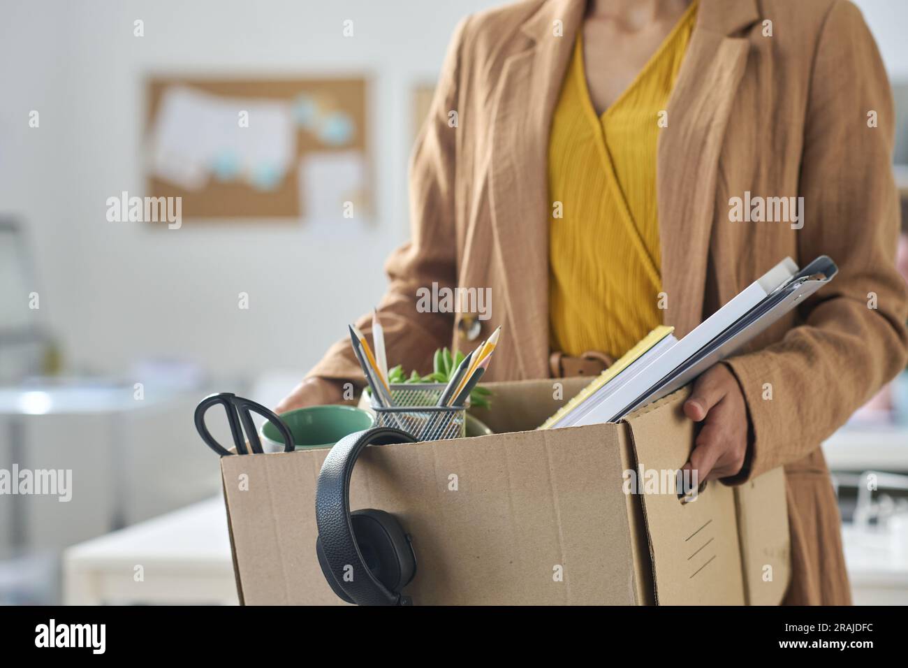 Close-up of businesswoman packing things in box while moving in new office Stock Photo