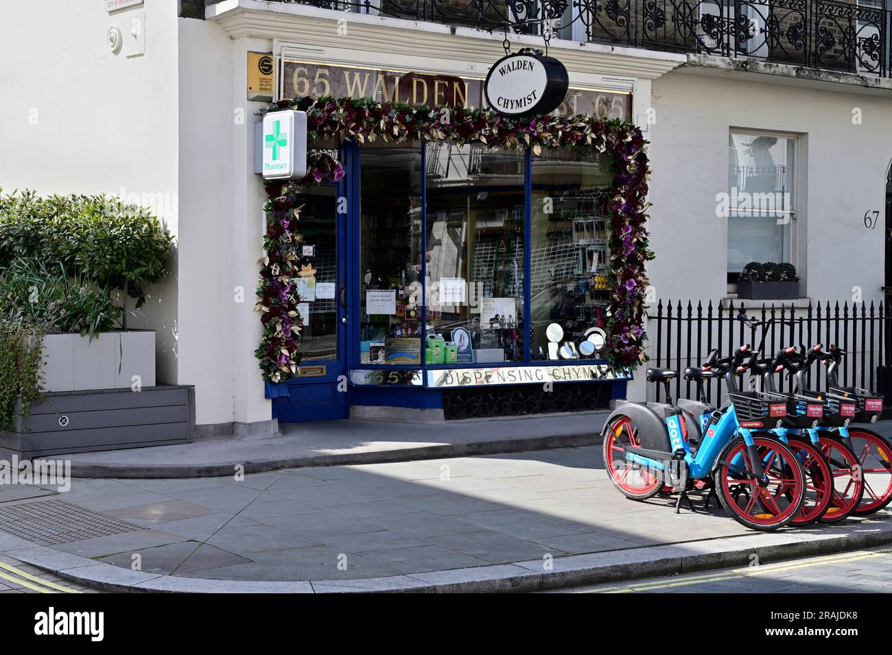 Walden Chymist (chemist) shop and electric Cycle Hire, Elizabeth Street, Belgavia, West London, United Kingdom Stock Photo