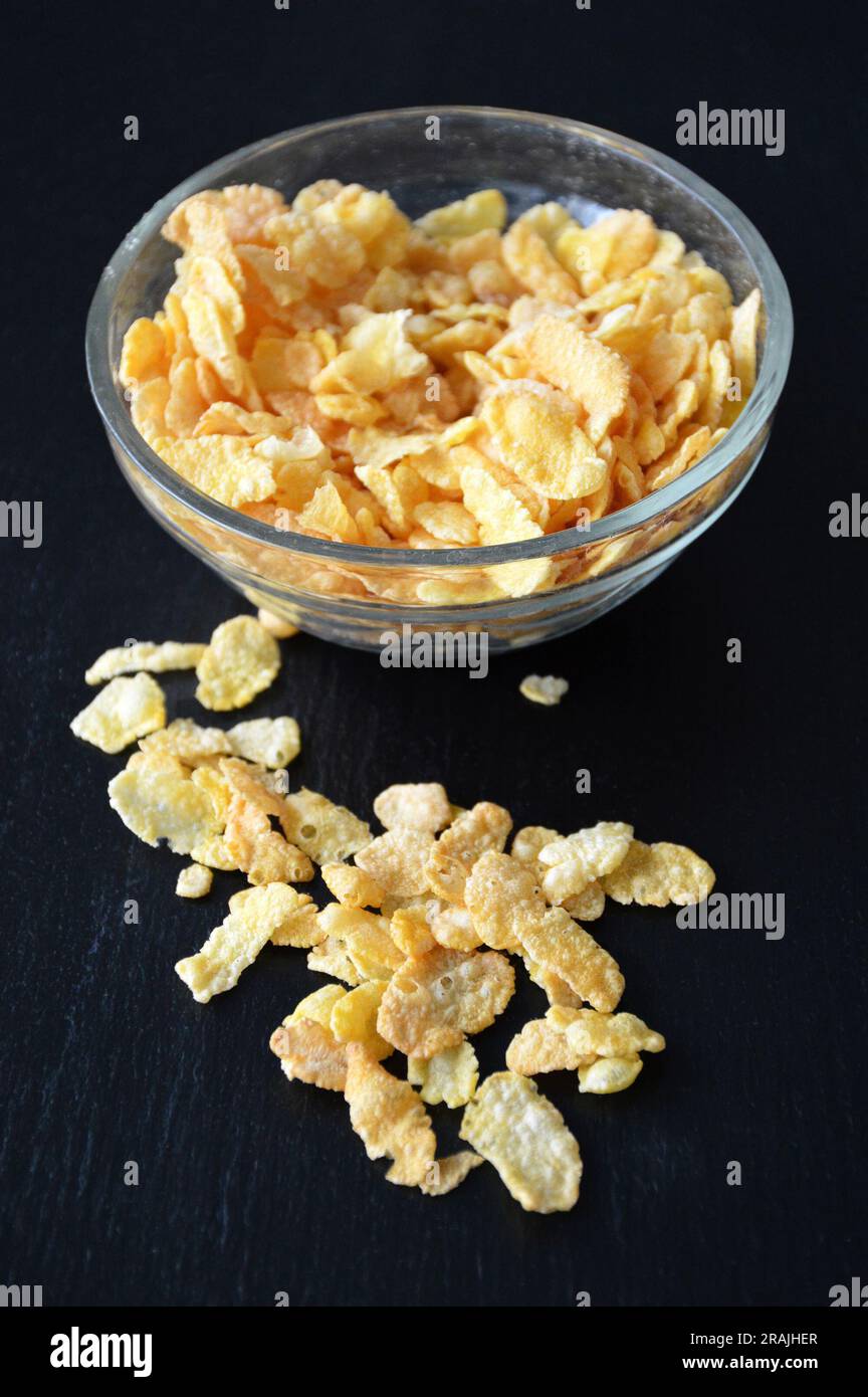 Corn-flakes in a bowl on black slate background Stock Photo