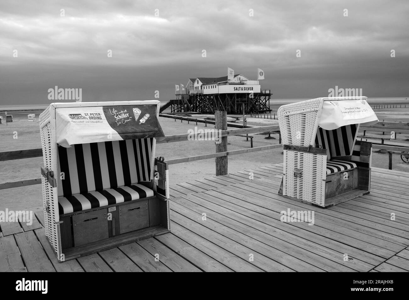 DEU, Deutschland, Schleswig-Holstein, St. Peter-Ording, 09.05.2023: leere Strandkörbe vor dem Restaurant Salt & Silver in einem der typischen Pfahlbau Stock Photo