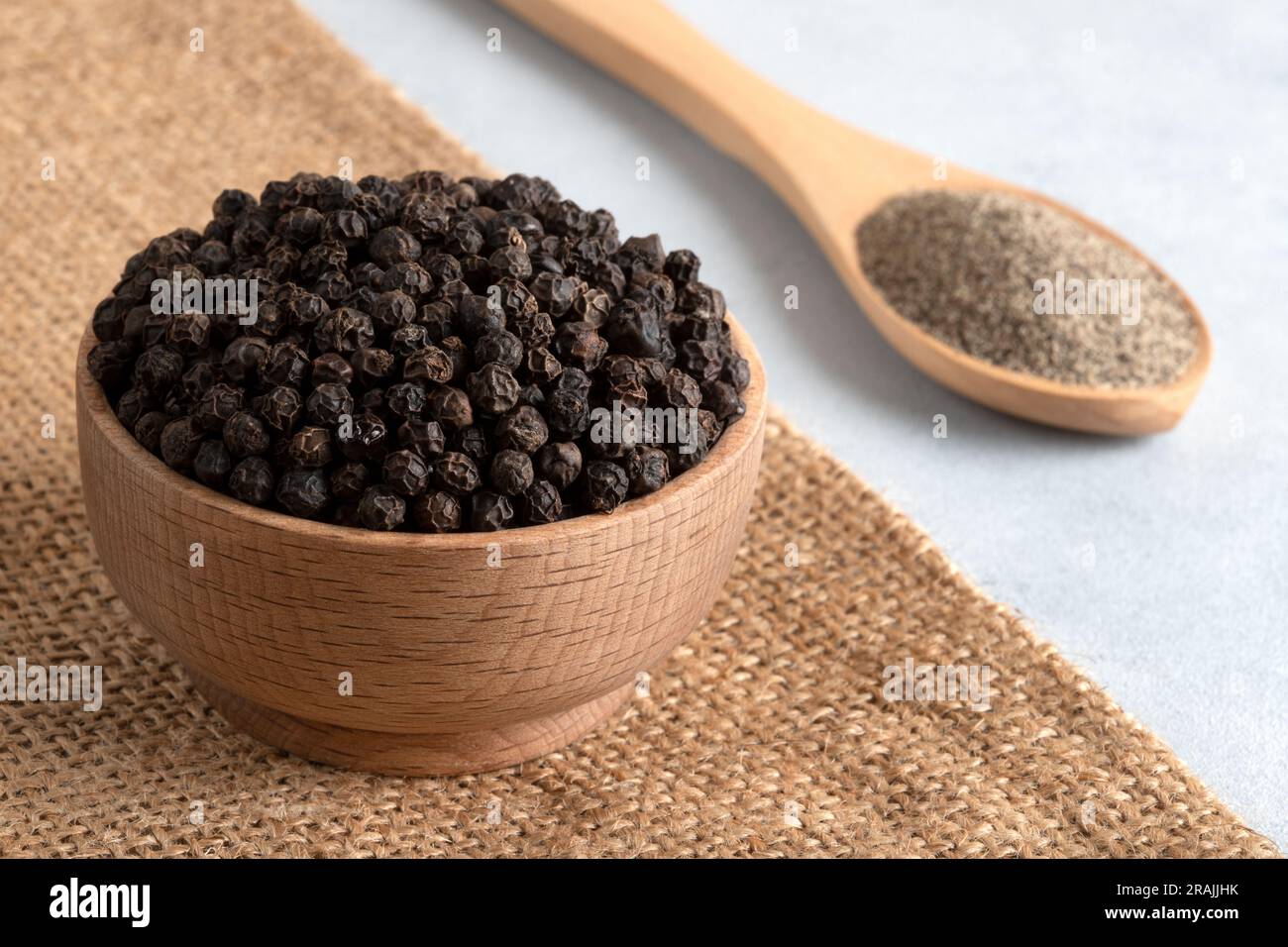 Ground black pepper with peppercorns on burlap sack Stock Photo Alamy
