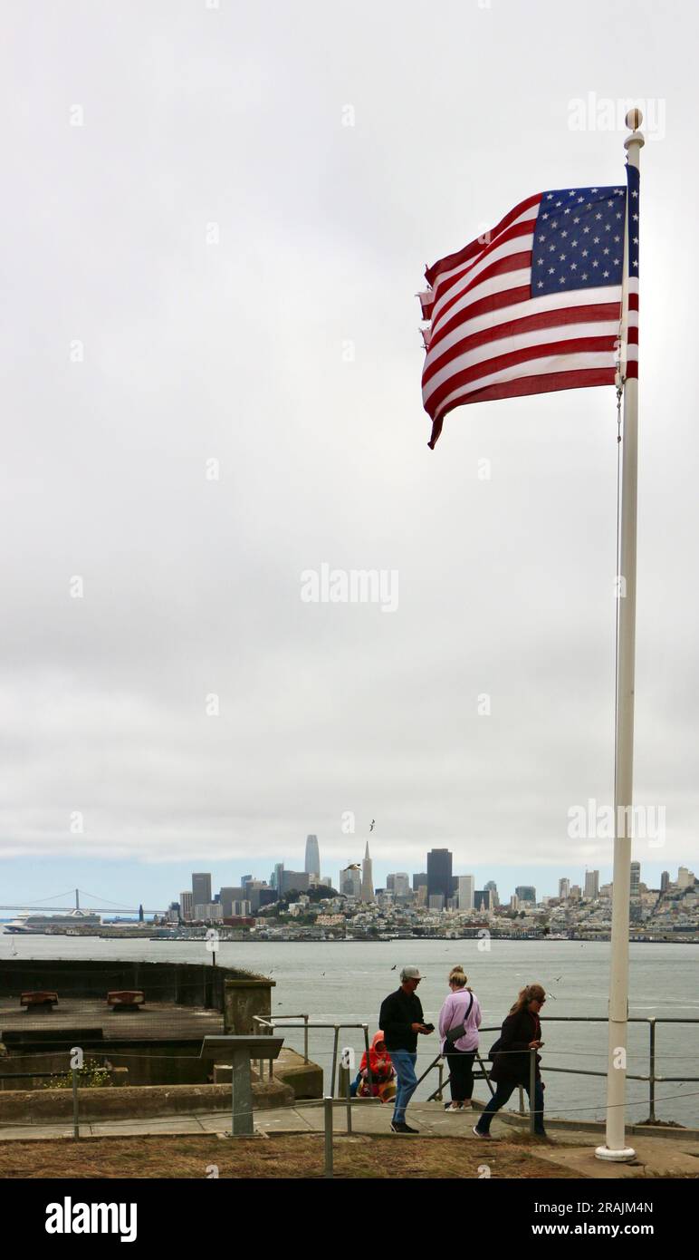 Looking towards the San Francisco skyline from Alcatraz Penetentiary Alcatraz Island and the Stars and Stripes flag San Francisco California USA Stock Photo