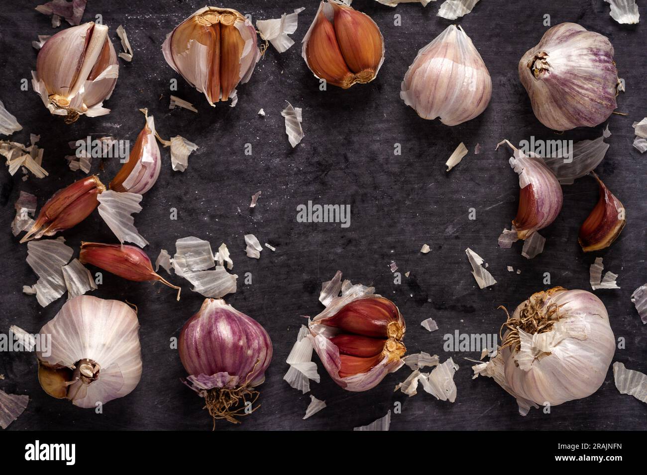 Fresh garlic bulbs and cloves grouped on black background. Flat lay ...