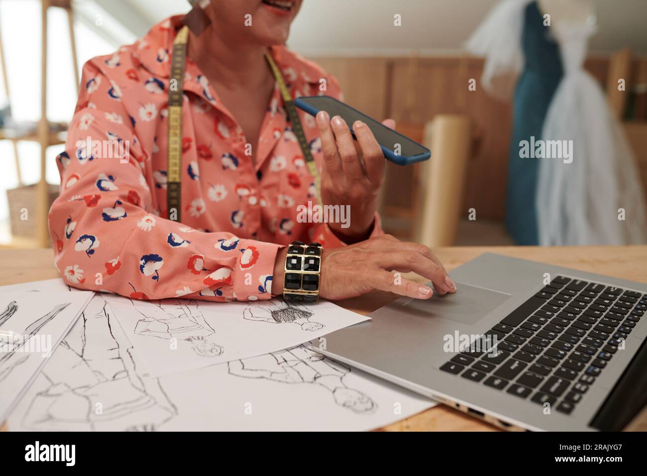 Tailor checking e-mails from clients and recording voice messages Stock Photo