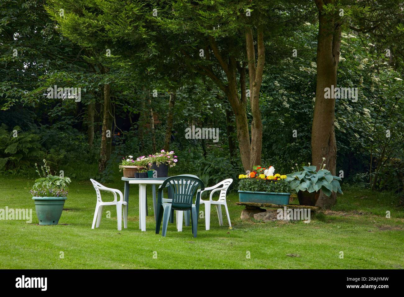 A sunny June day, and plastic garden furniture laid out on a lawn in the moorland smallholding garden. North Yorkshire Stock Photo