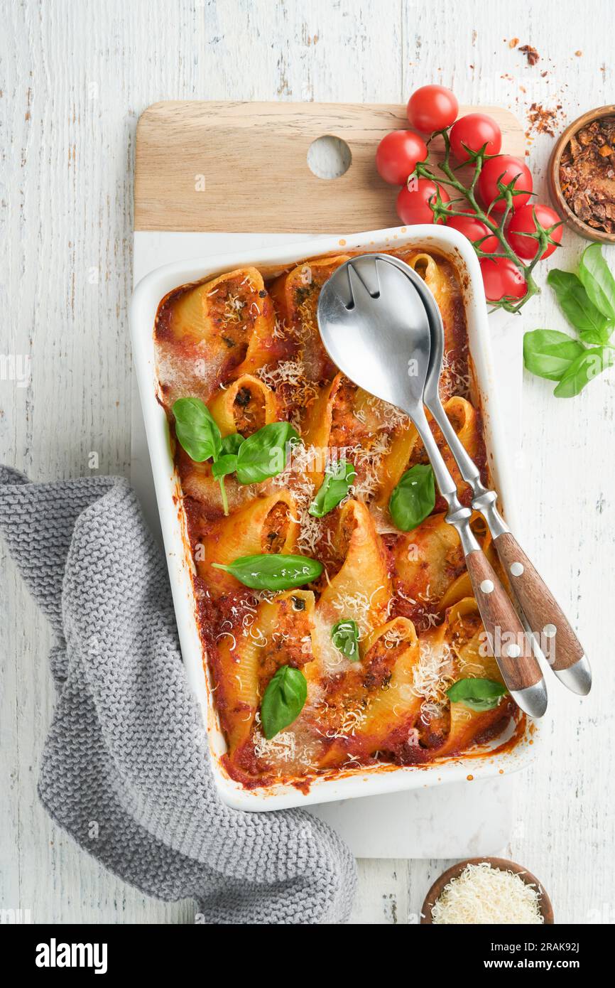 Cannelloni or conchiglioni. Baked stuffed pasta shells with bolognese