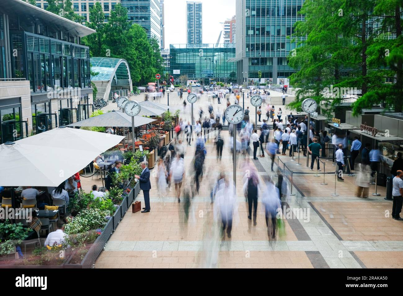 London- June 2023: Motion blurred business people in Reuters Plaza, London's Canary Wharf financial district. Stock Photo